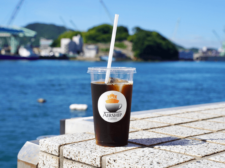 写真:海を背景にアイスコーヒー